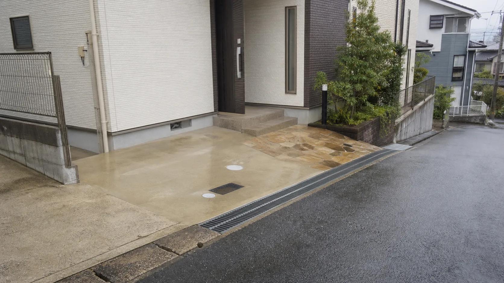 道路から玄関までの勾配と排水溝を確認できる日本の戸建て住宅