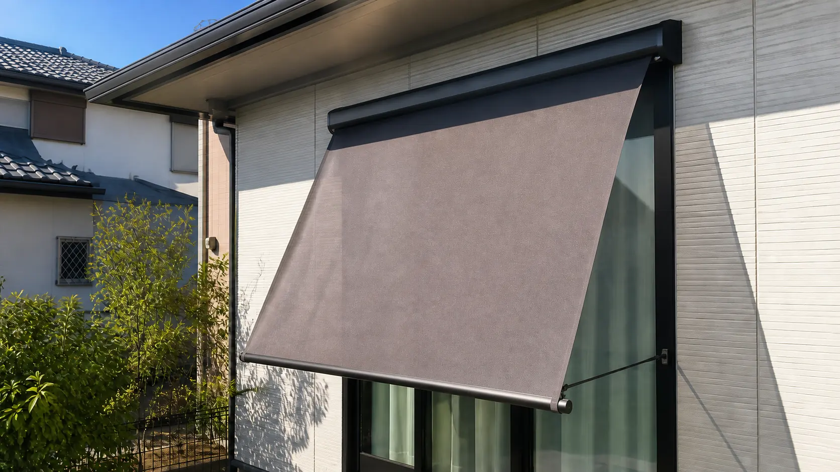 西日を窓の外側で遮る外付けロールスクリーンを設置した日本の戸建て