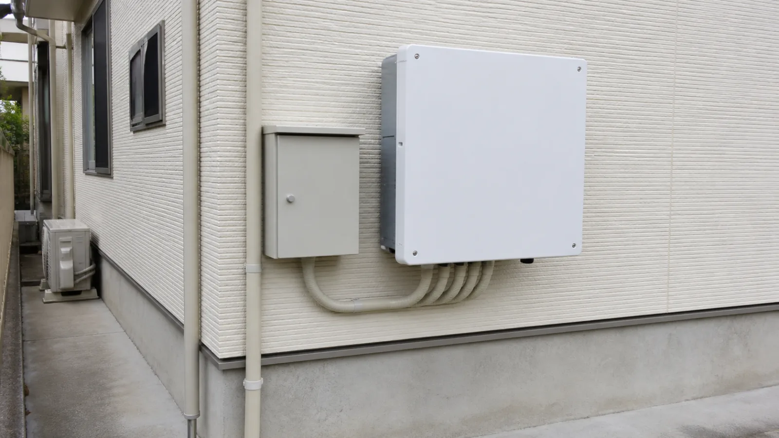 住宅の壁面に設置された太陽光発電用パワーコンディショナ