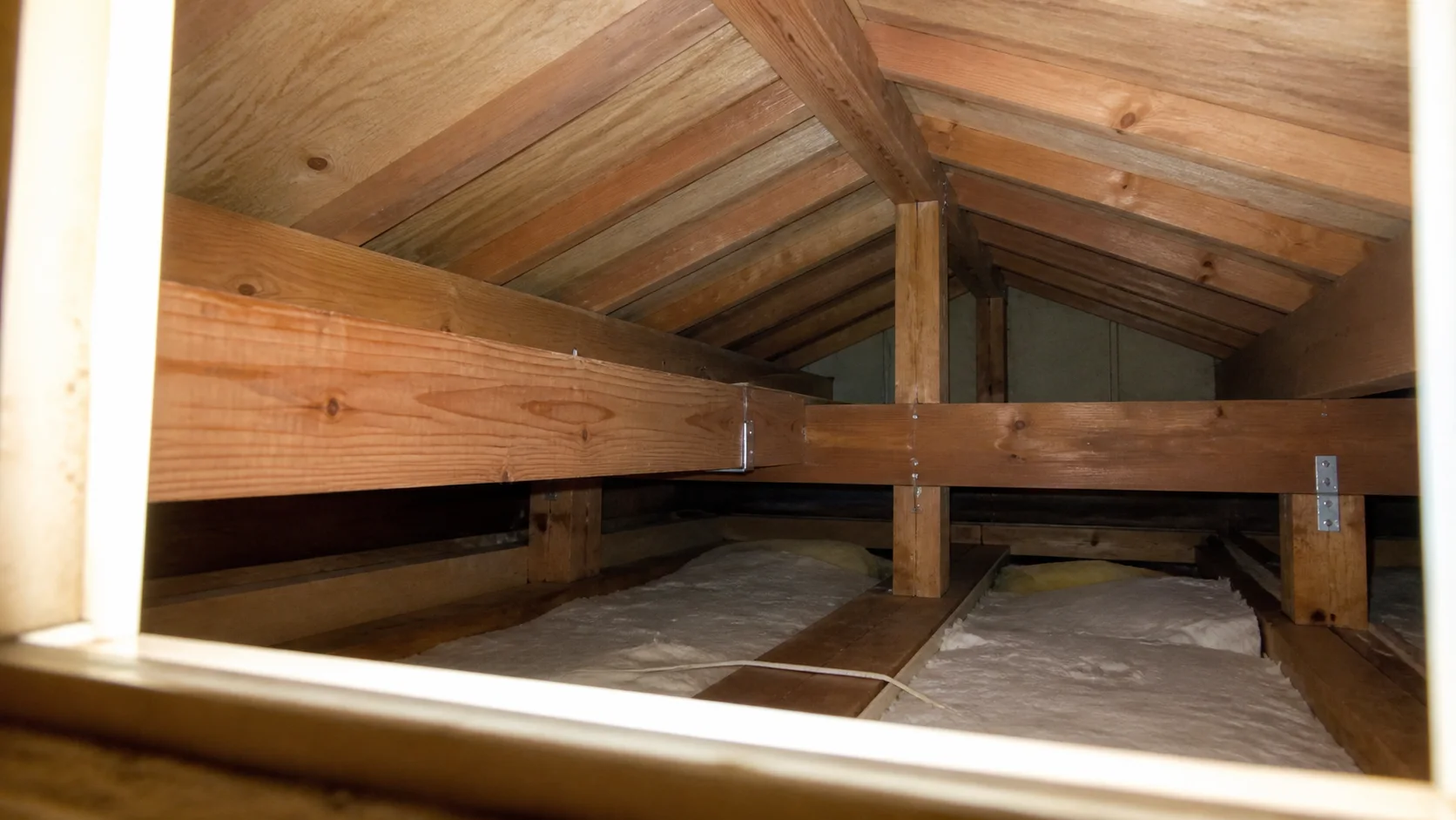 中古木造住宅の梁と垂木と断熱材が見える小屋裏