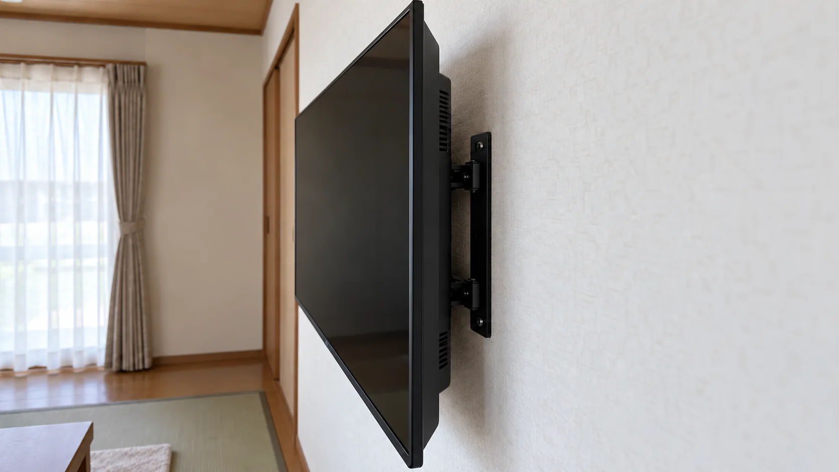 壁掛けテレビの背面と壁の間に取り付けられた金具